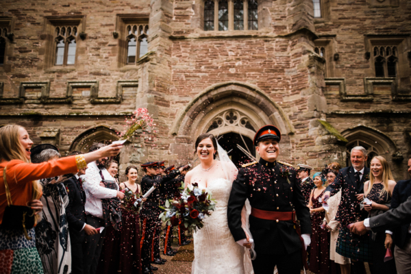 Couple in courtyard with guests throwing confetti