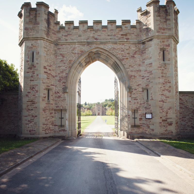 A gateway with a drive leading straight down to a castle
