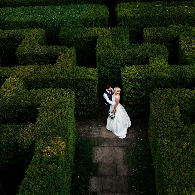 Wedding couple standing in Maze in gardens