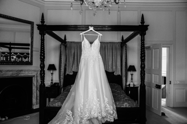 Wedding dress hanging from four poster bed