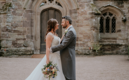 Bride and groom smiling at each other in centre courtyard