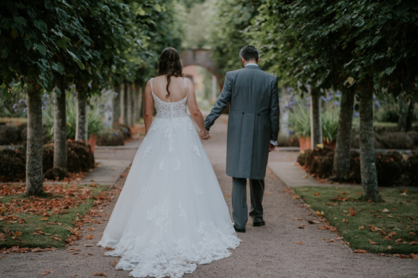 Couple walk away from Camera as they explore the gardens