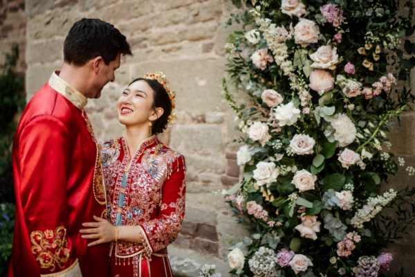 bride and groom in traditional Chinese wedding outfits outside Hampton Court Castle venue