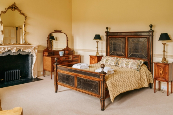 Unique looking bedroom with ornate period furniture and fireplace